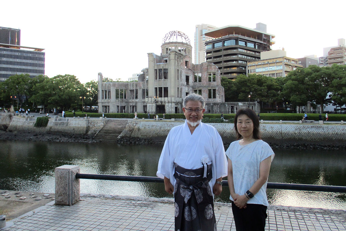 原爆ドームを背景に永原順子大阪大学講師と、WCRPを代表して慰霊碑に献花をする三宅善信代表