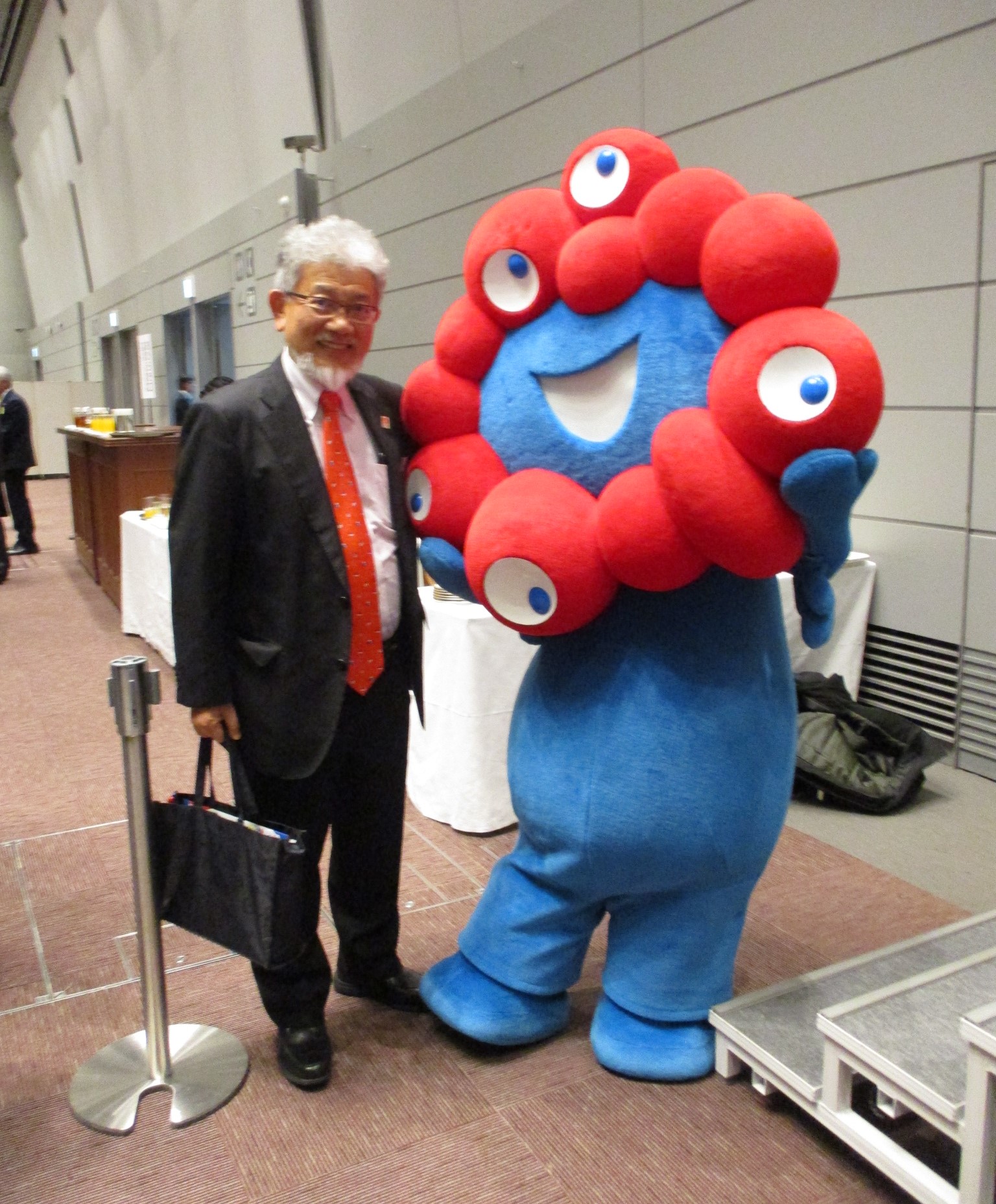 新年互例会の会場でミャクミャクとツーショットに収まる三宅善信代表