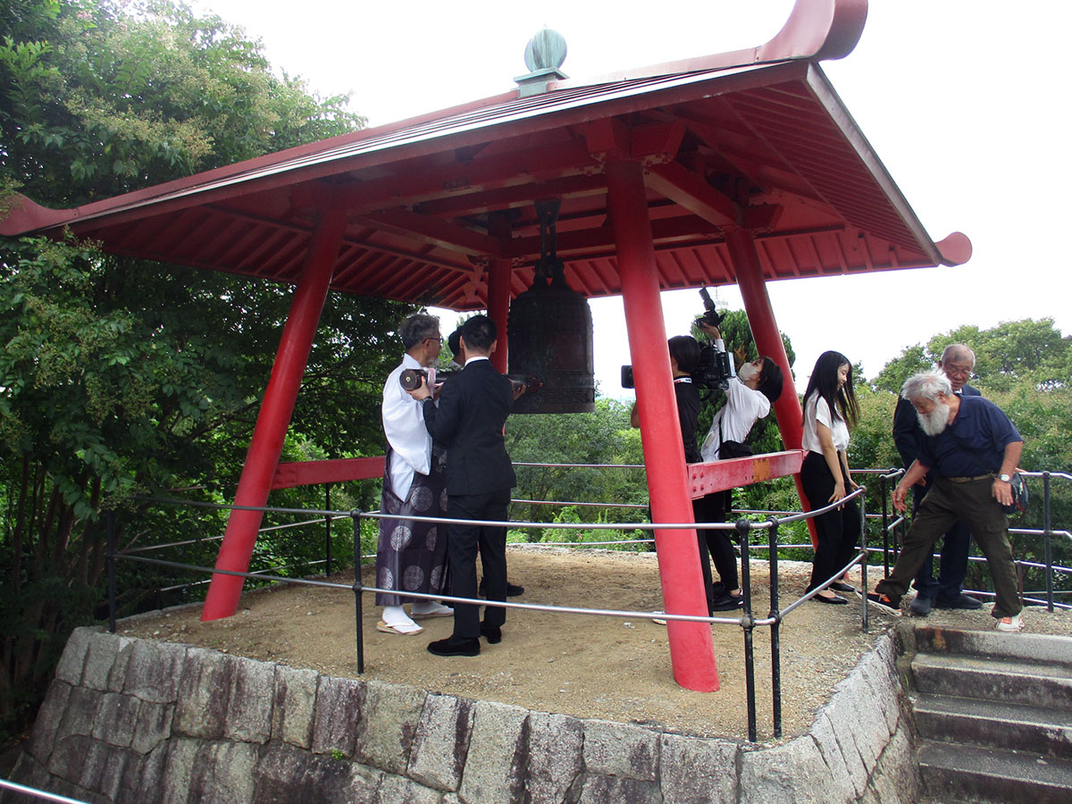 花博記念公園の「平和の鐘」を鐘打する三宅善信関西国連協会理事長ら